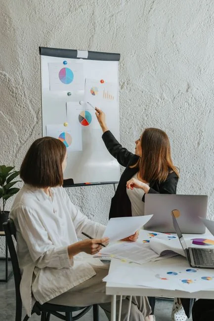 Une équipe examine des graphiques financiers et des données numériques sur des tablettes dans un environnement de bureau.